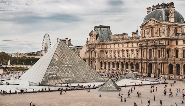 Exterior view of the Louvre. You can see the large main pyramid, two small pyramids, and a stone museum building