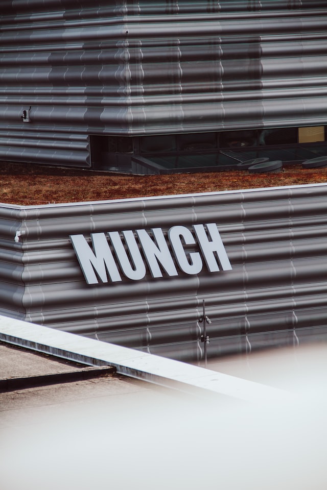 A metal sign affixed to a building that says Munch
